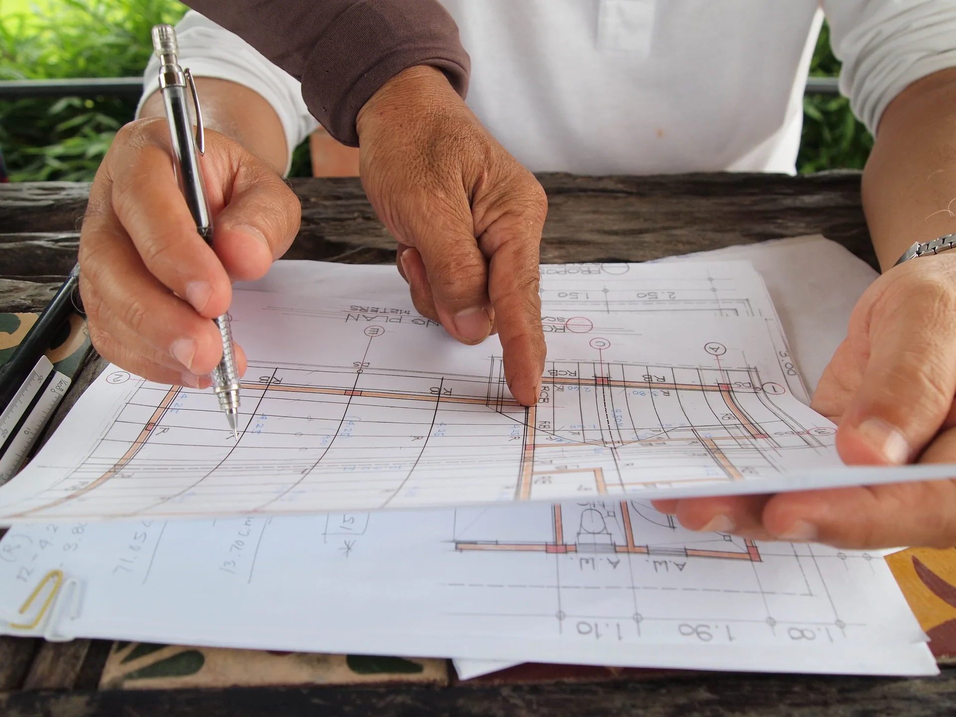 Hands reviewing detailed architectural plans